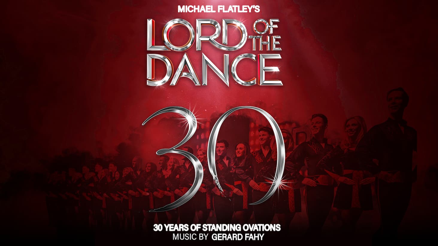 A dramatic promotional poster with a deep red background advertising “MICHAEL FLATLEY’S LORD OF THE DANCE.” The title appears in large, metallic silver letters across the top half, with a glossy, reflective effect and bright highlights. Above it, smaller white text reads “MICHAEL FLATLEY’S.” In the centre foreground, a performer in a light-coloured jacket is captured mid-dance, facing away from the viewer with one arm extended outward. The movement is dynamic, suggesting a traditional stage performance. Overlaid across the lower middle is a large, metallic “30”, styled to match the title text, marking an anniversary. Behind the central figure, a group of dancers in coordinated dark costumes lines the background in a low-lit, red-toned scene, forming a chorus-like arrangement. At the bottom, white text reads “30 YEARS OF STANDING OVATIONS” and “MUSIC BY GERARD FAHY.” The overall design is bold and theatrical, using rich red tones and metallic typography to convey celebration and spectacle.