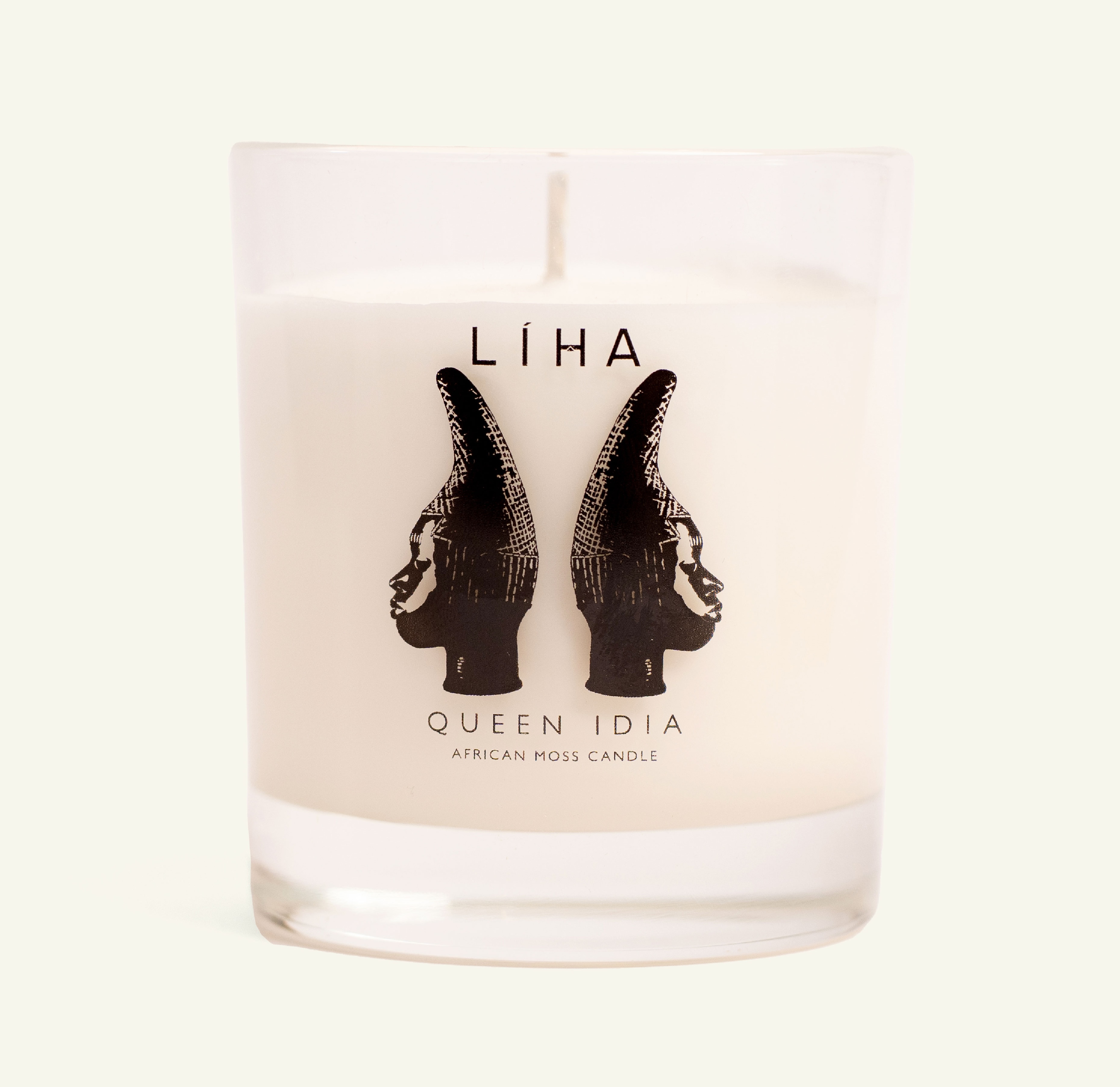 A glass candle adorned with the Queen Idia mask and LIHA Beauty Logo