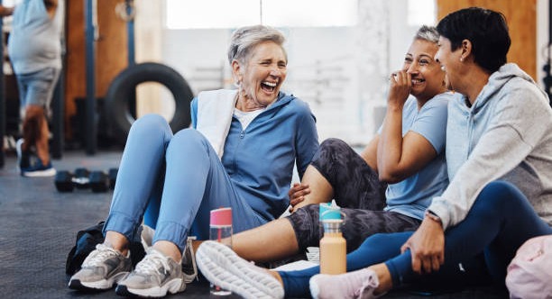 group of women laughing in workout clothes