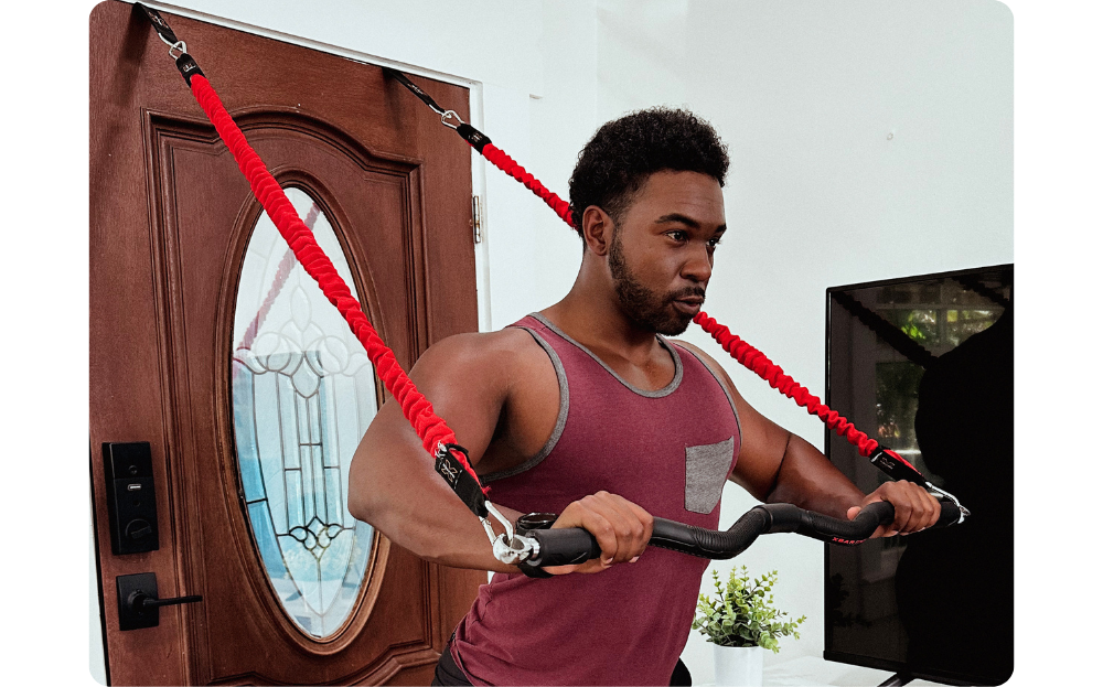 Portable home gym setup featuring door anchor attachments and a heavy-duty resistance band bar for upper body strength training.