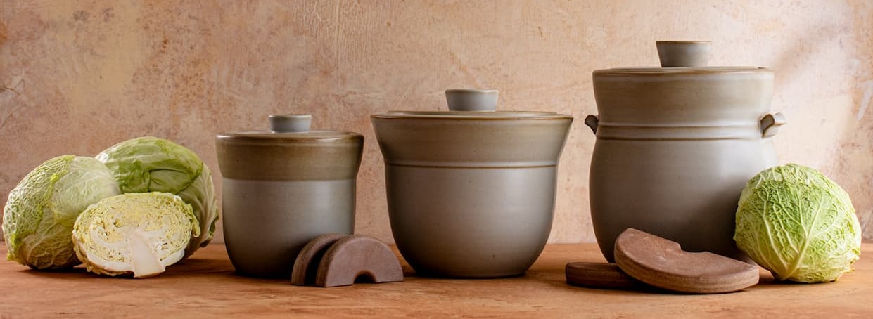 fermentation jars in three sizes with cabbages and weights