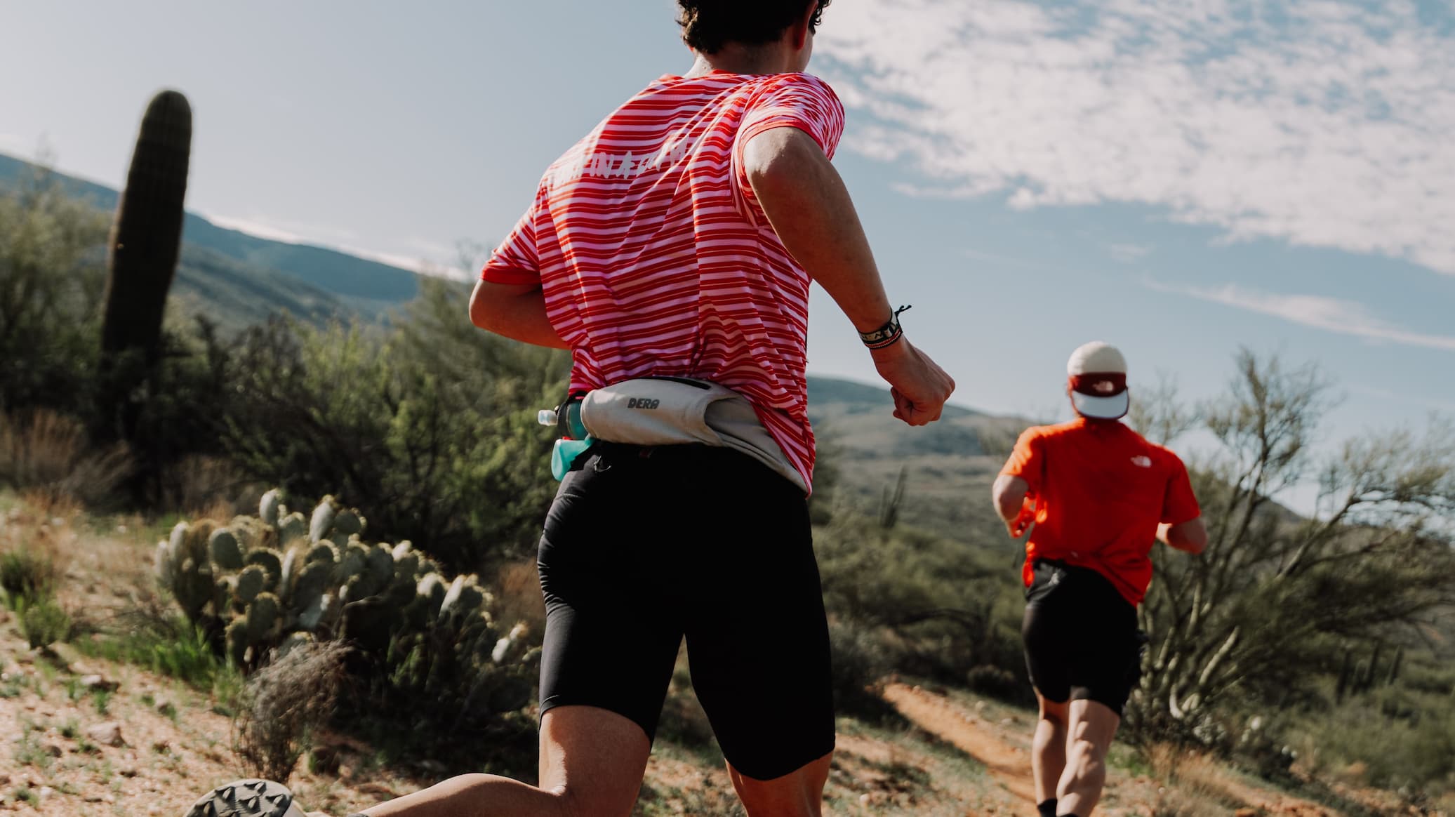 Two people running on a trail in the desert