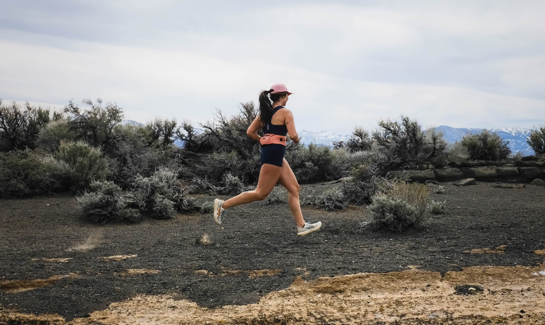 Two people running on a trail in the desert