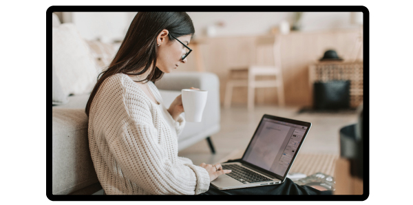 Woman sitting at her laptop with coffee, writing