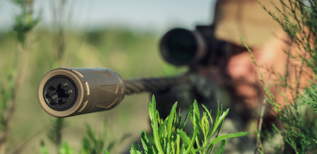 Rifle suppressor detail in tactical setup.