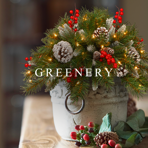 Holiday greenery arrangement with pine branches, pinecones, and red berries in a decorative pot.