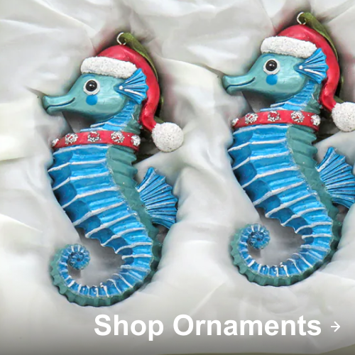 Blue seahorse Christmas ornaments wearing red Santa hats displayed on white fabric.