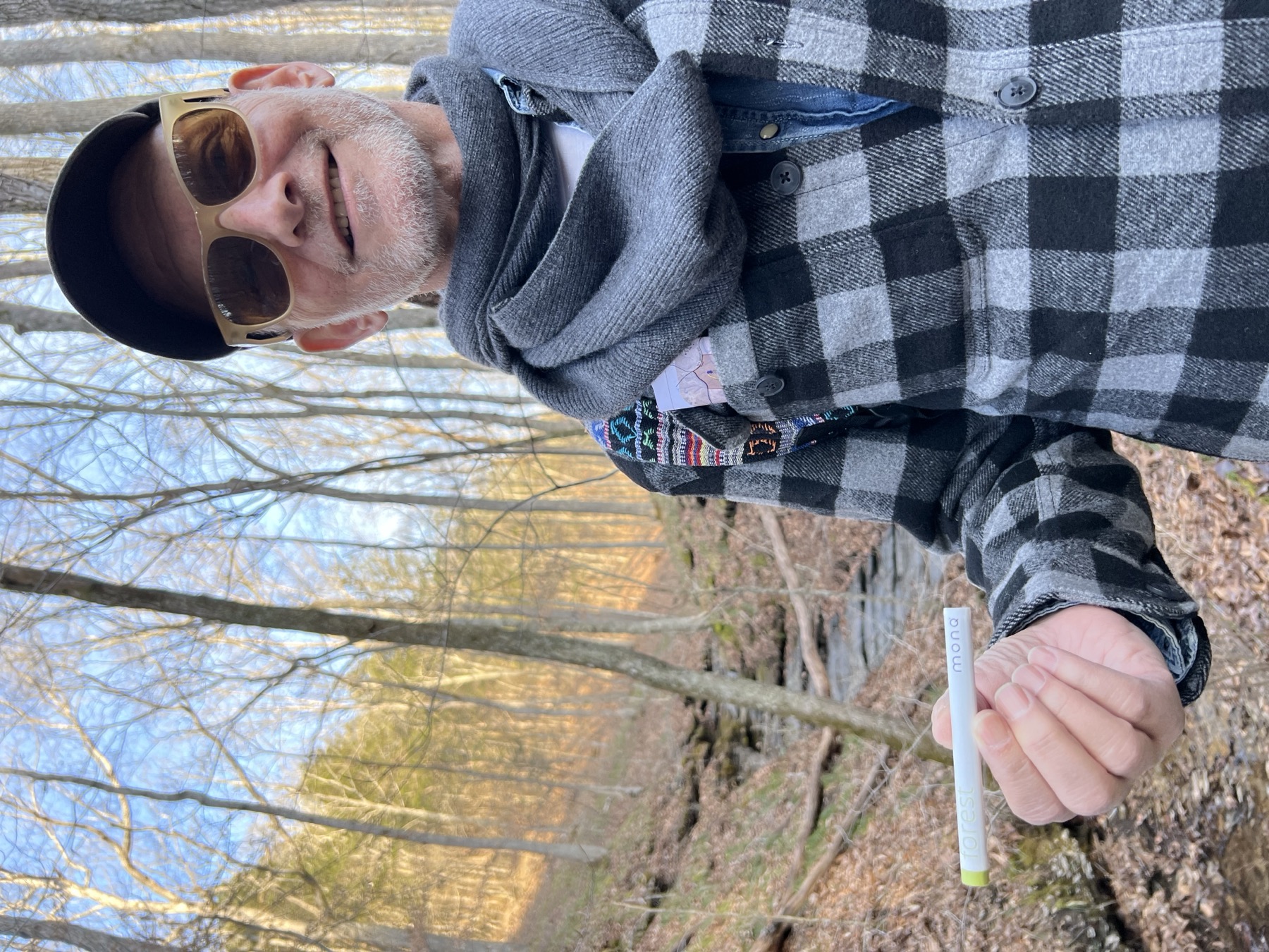 Man inhaling MONQ diffuser in a winter forest — breathing botanical aromatics outdoors, the way the olfactory system evolved to receive them