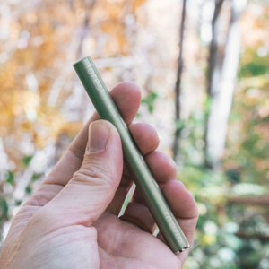 Hand holding MONQ forest diffuser against warm autumn foliage — the golden palette of nostalgia and scent-triggered memory