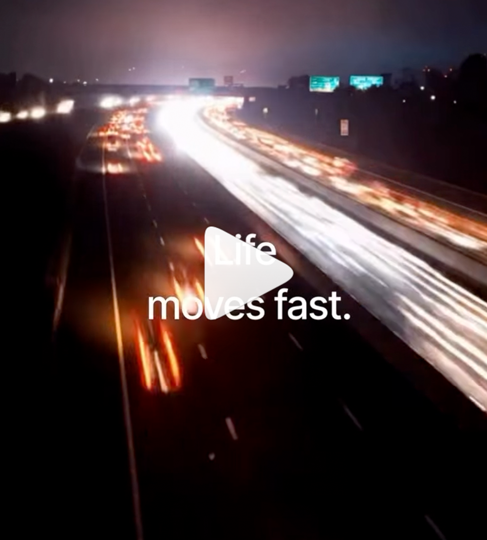 A screenshot of a video showing highway traffic moving quickly at night, with car headlights blurring, while text over the video reads "Life moves fast." 