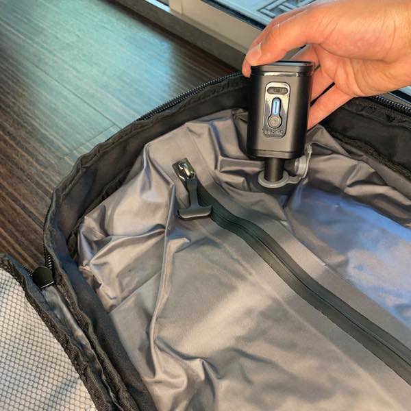 Using a mini travel vacuum on a backpack’s compression compartment
