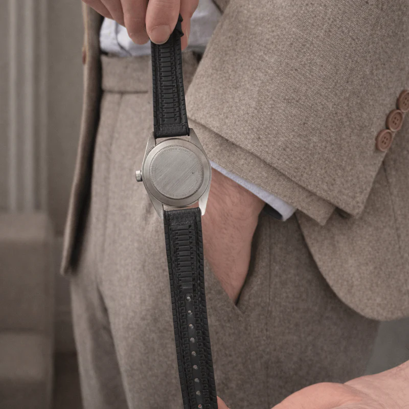 an image of a man in a suit holding a watch