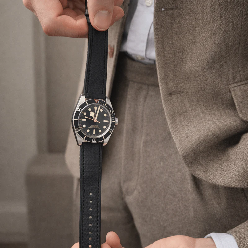 an image of a man in a suit holding a watch