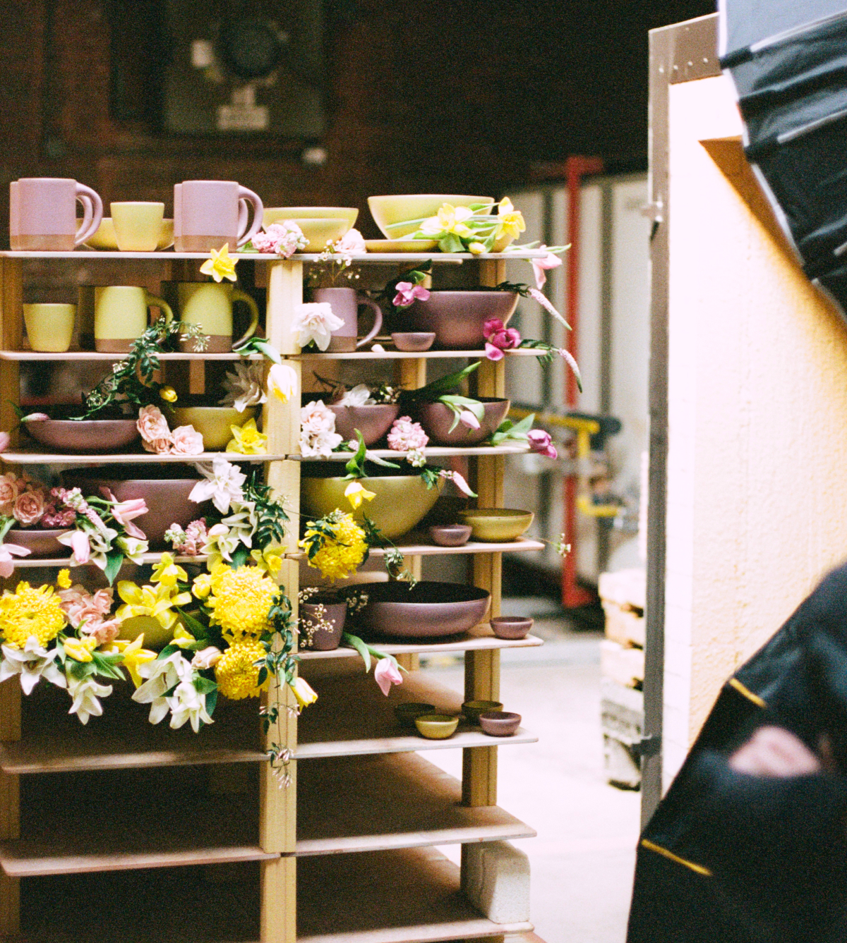 A kiln rack of purple and yellow pottery, with flowers all over it.