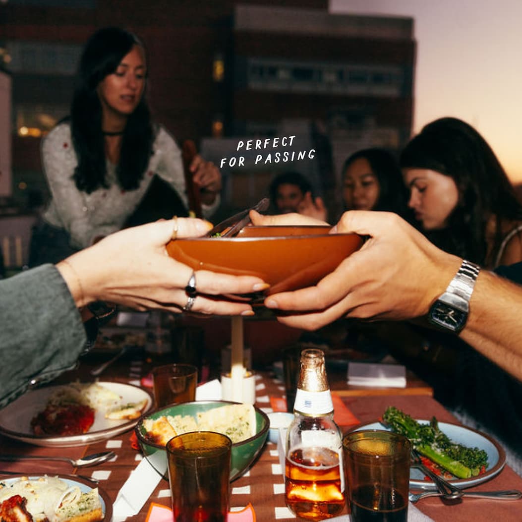 A bowl is passed between hands across a table A bowl is passed between hands across a table