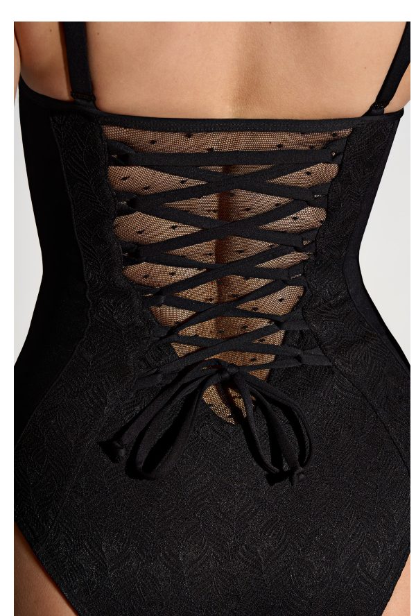 Laced back detail of a black swimsuit with a mesh panel.