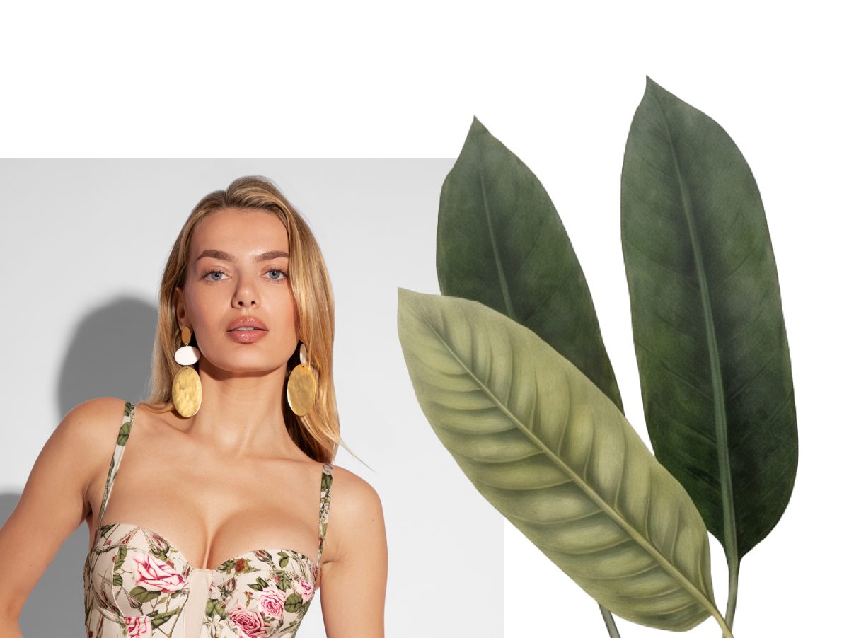 A woman in a thorny rose bombshell swimsuit and earrings, next to two green leaves.