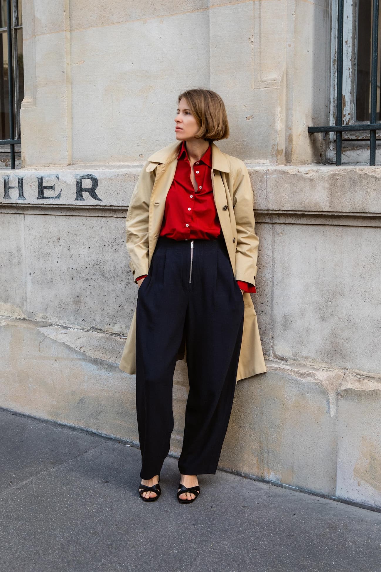 an image of a woman standing on the sidewalk in front of a building