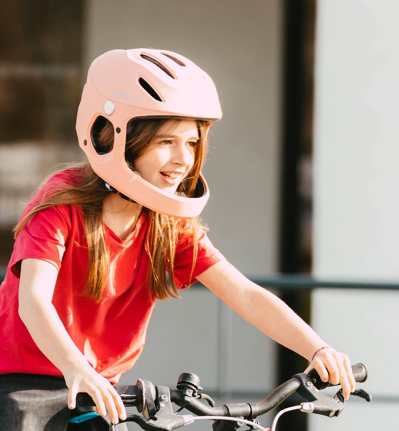 Enfant à vélo portant un casque Virgo Kid rose