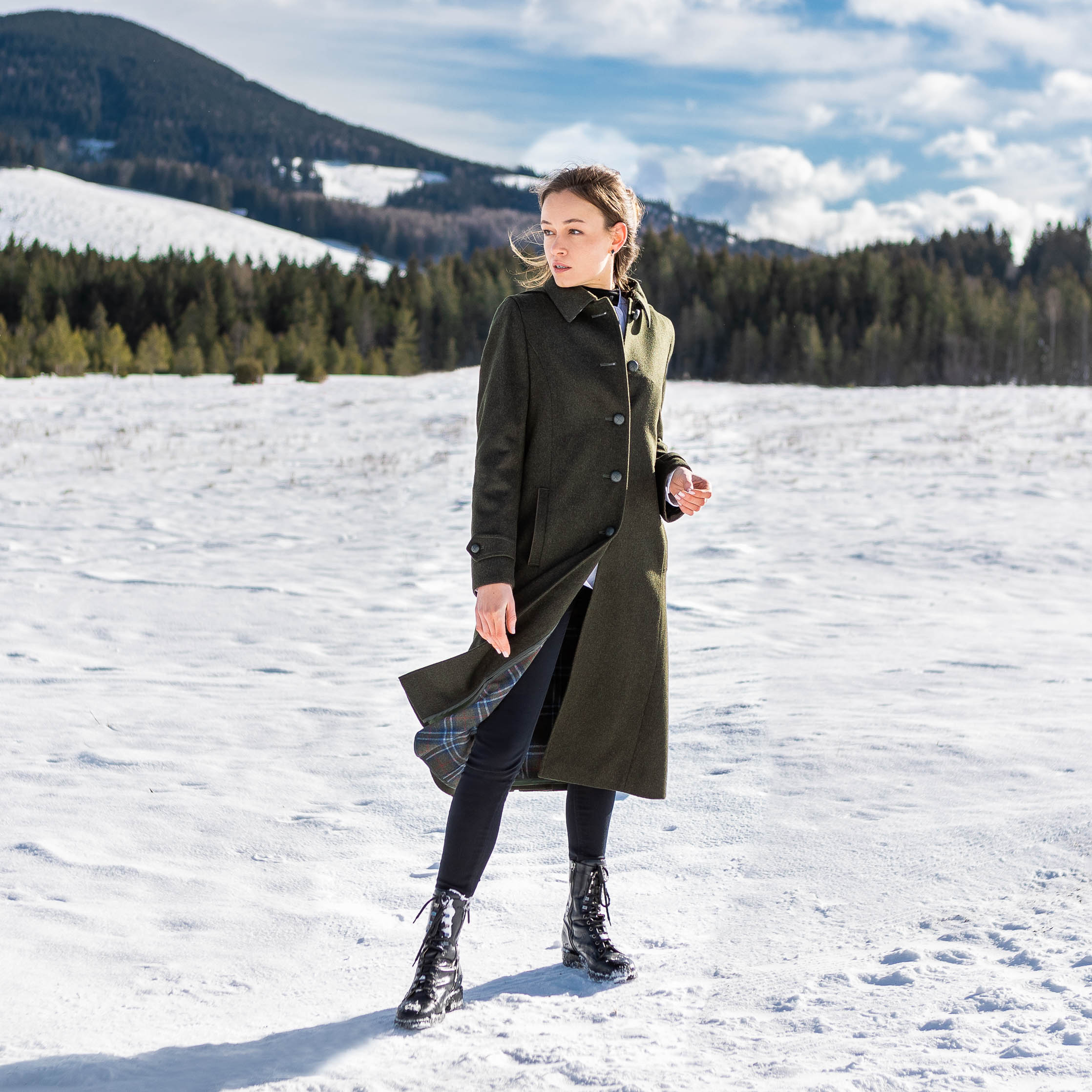 young women wearing a Robert W. Stolz loden coat in olive standing in a snowy alpine field