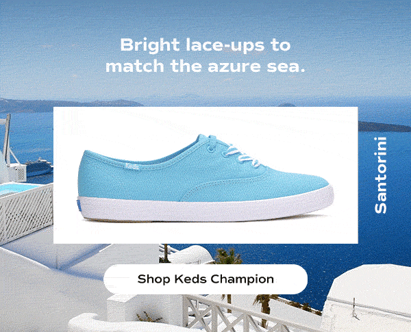 The headline reads: Bright lace-ups to match the azure sea. A side view of the Keds Champion Canvas Lace-Up in light blue sits on top of an animated background of Santorini's crisp white buildings and deep blue sea. Shop Keds Champion.