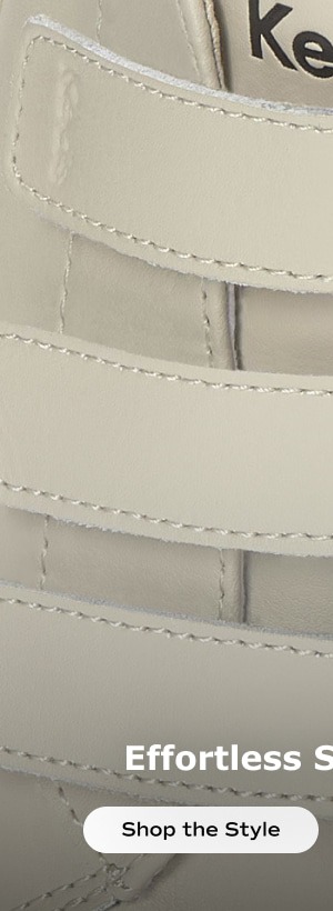 A zoomed-in view of the top of the Jump Kick V Calf Hair Heel in egret showcasing the three hook-and-loop strap closure. Shop the style.