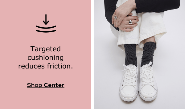 The Center III Leather Lace-Up in white shown on foot paired with scrunched dark gray socks and cream-colored twill pants. White text on a blush background says, Targeted cushioning reduces friction. Shop Center.