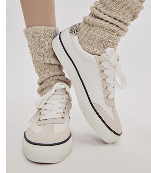 The Jump Kick T-Toe Leather/Suede Hair Calf Heel Lace-Up in off white/beige paired with ribbed, scrunched tan socks.
