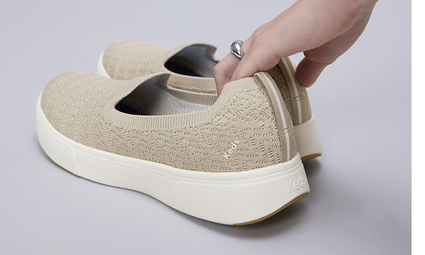 Someone holding the BlissWalk Knit Loafers in Taupe.
