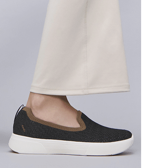 The BlissWalk Knit Loafer in black/cognac paired with beige flared pants.