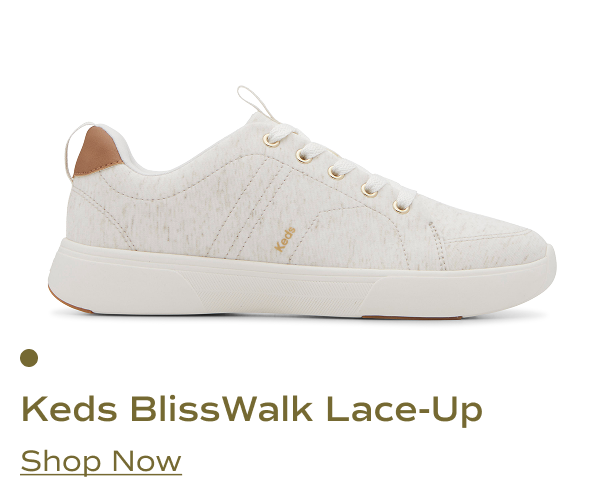A side view of the Keds BlissWalk Jersey Lace-Up shoe in off-white. The shoe features a breathable fabric upper, gold-tone eyelets, a cushioned sole, and a brown accent on the heel. Shop Now.