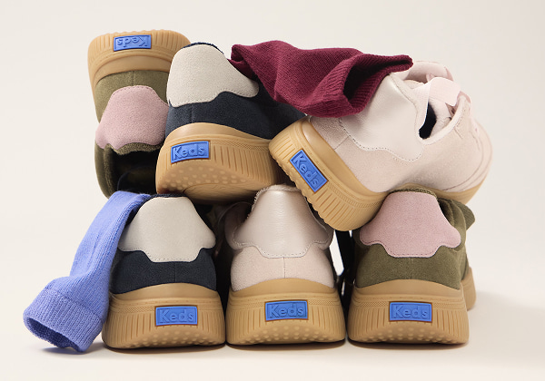 A pile showcasing the backs of the Contest Suede Lace-Up in olive/pink, navy/grey, and light pink.