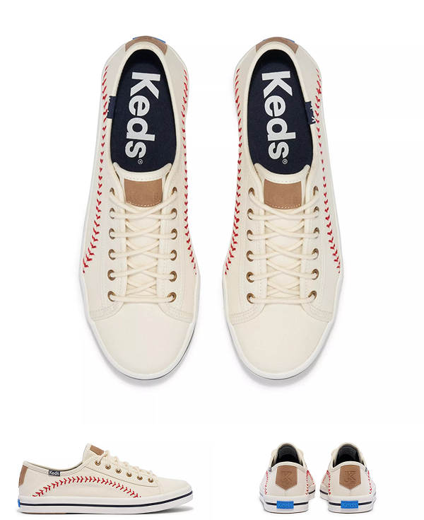 A product image displaying multiple views of the Keds Kickstart Pennant canvas lace-up sneakers in white, featuring red baseball-style stitching, brown leather heel tabs, and blue logo detailing on the heel. Top-down view shows navy insoles with bold white Keds branding.