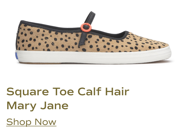 A side view of the Square Toe Mary Jane in tan and black calf hair. The shoe features a textured calf-hair upper with an all-over black spotted animal print, a black strap with a round orange buckle, black trim along the collar, and a white rubber sole. Shop Now.