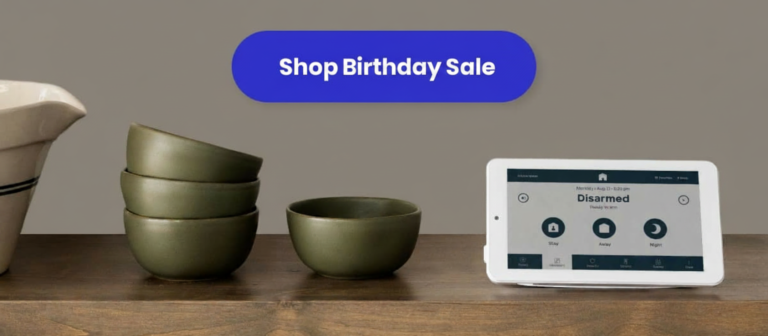 A tablet displays a "Disarmed" security system status next to a stack of green bowls.