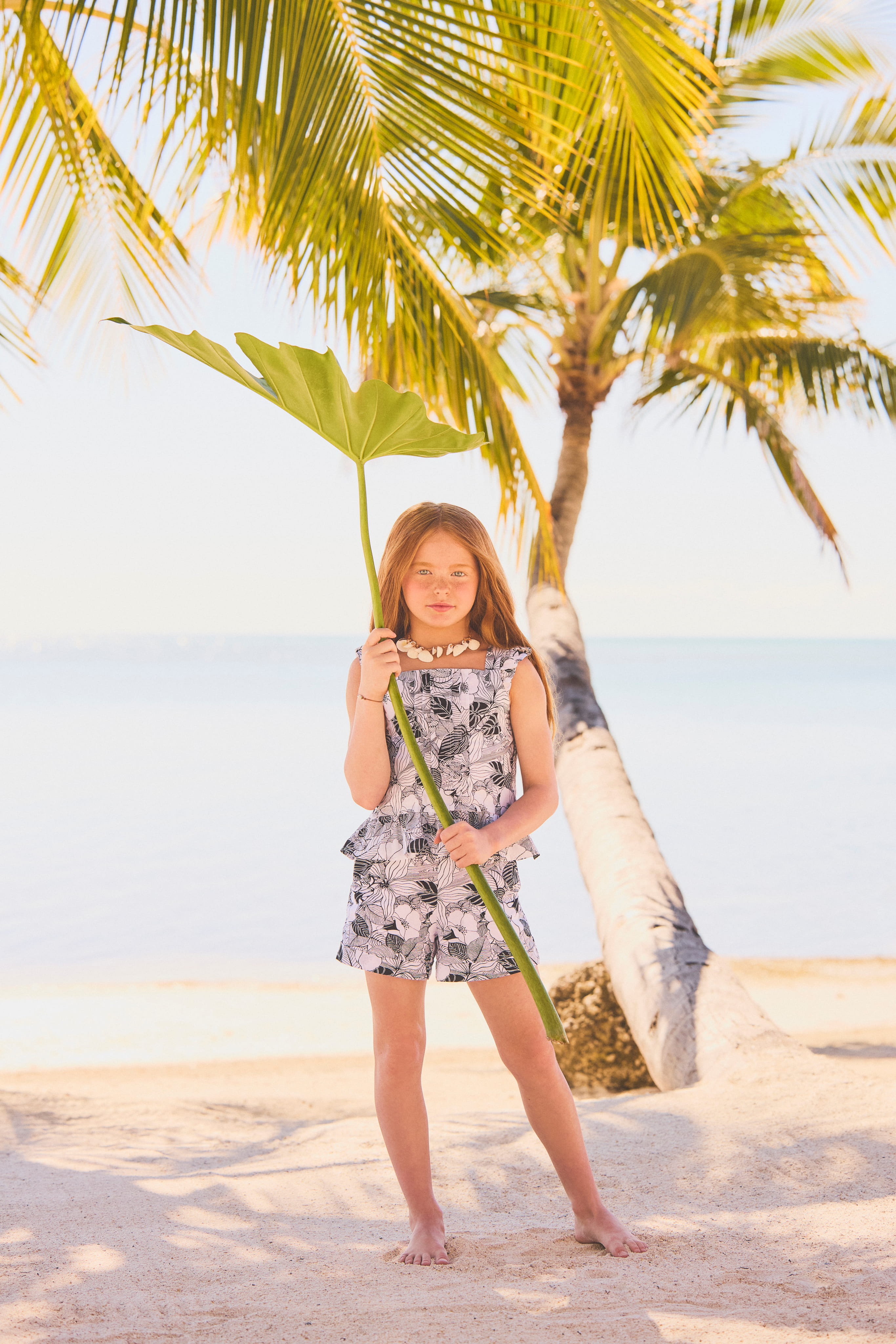 Image of Girl holding leaf at sea shore