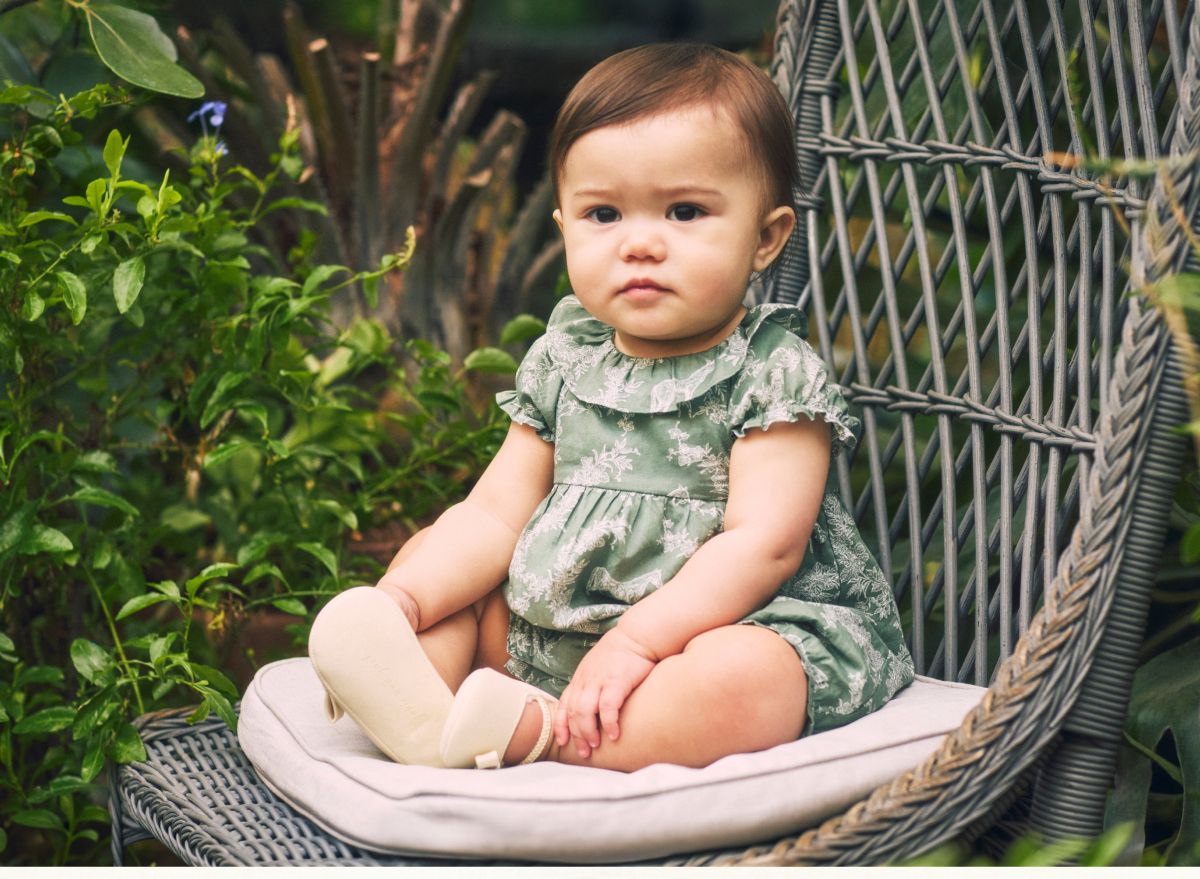 Baby wearing The Horse Toile Ruffle Dress