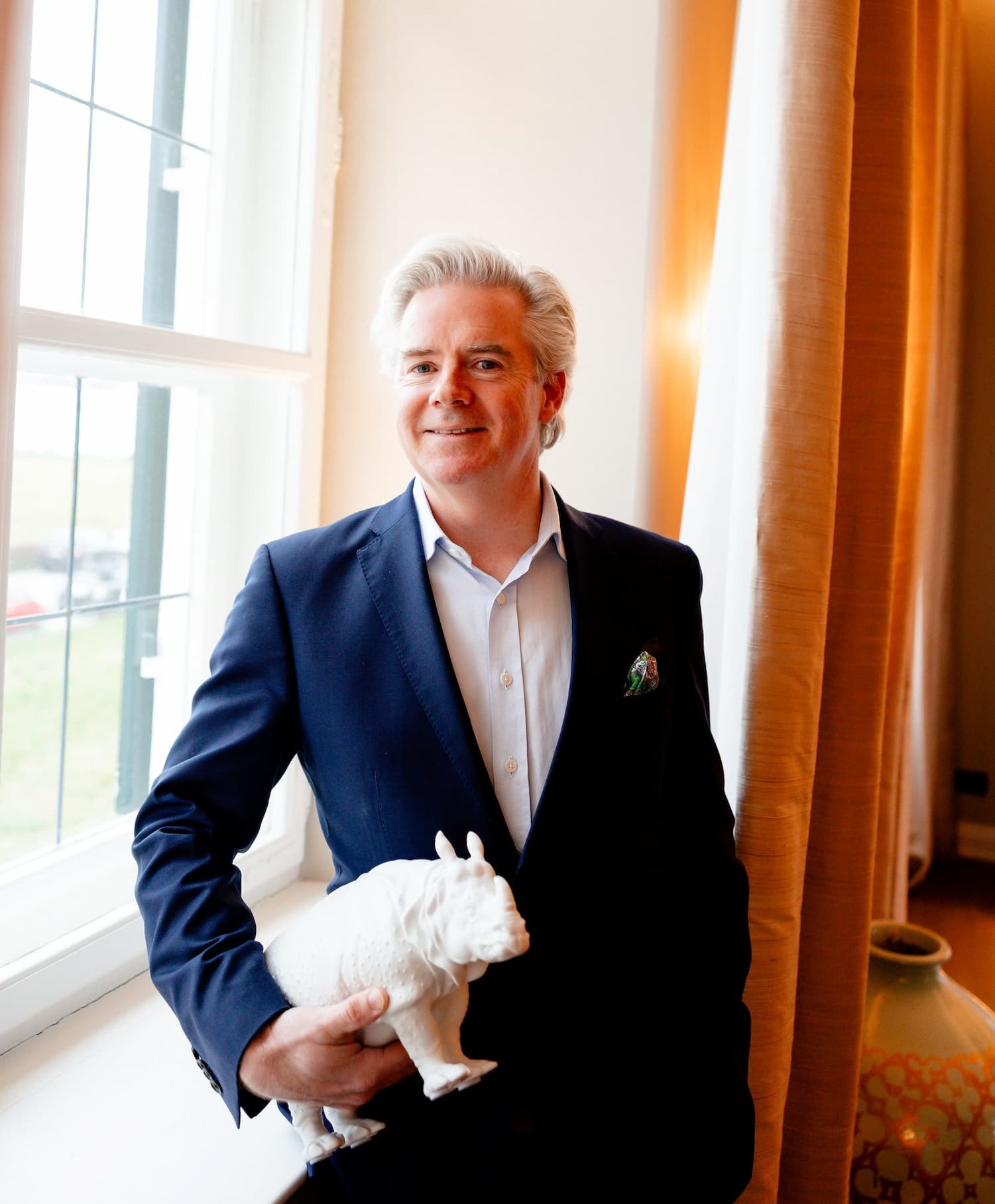 Anders Thomas mit Porzellan-Nashorn Clara am Fenster