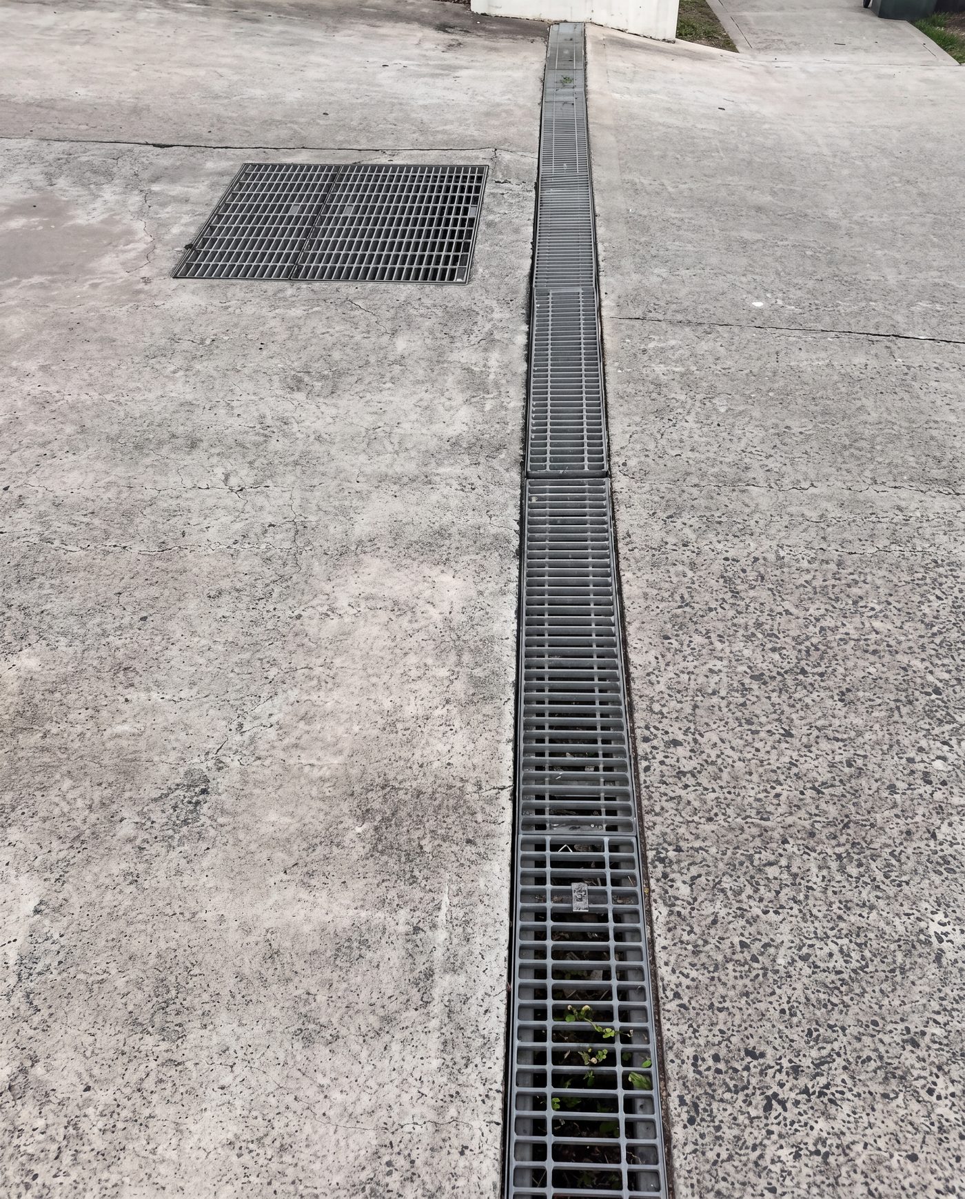 The full run of trench drain with galvanised grates in place