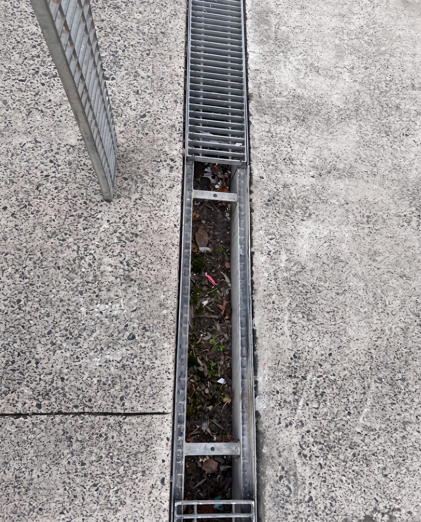 The channel with grates removed, exposing the eroded foundation beneath