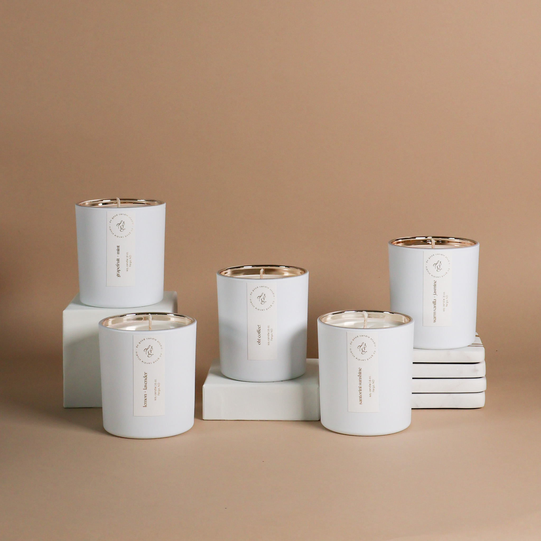 styled image of 5 candles in Signature White Collection on white props with beige background