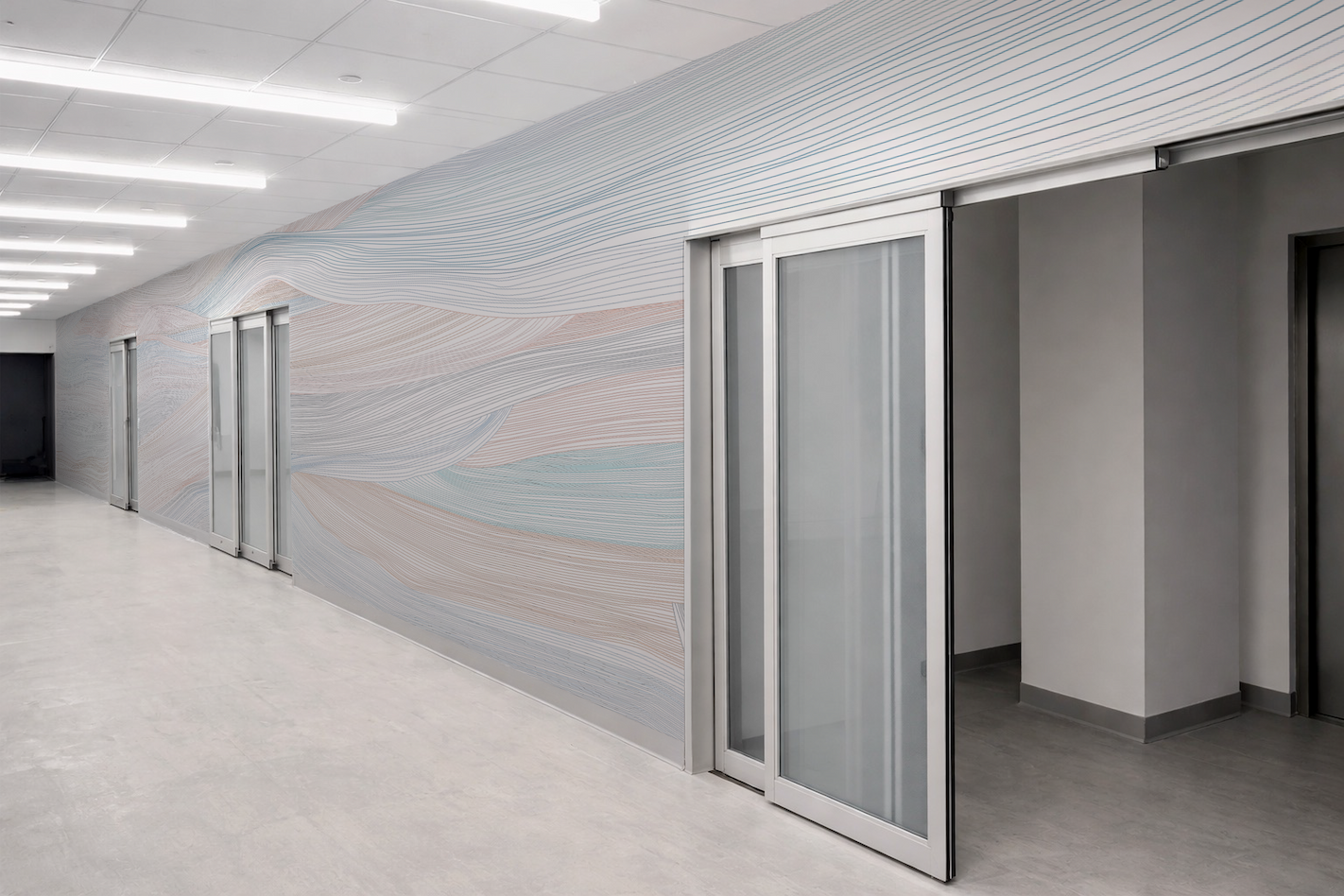 Healthcare corridor featuring FLOW | PASTURES wallcovering for NYU Langone facilities designed by Ewing Cole