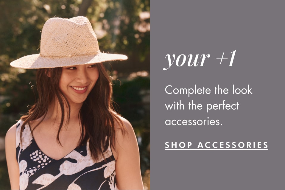 Woman wearing a straw hat and a black and white floral dress.