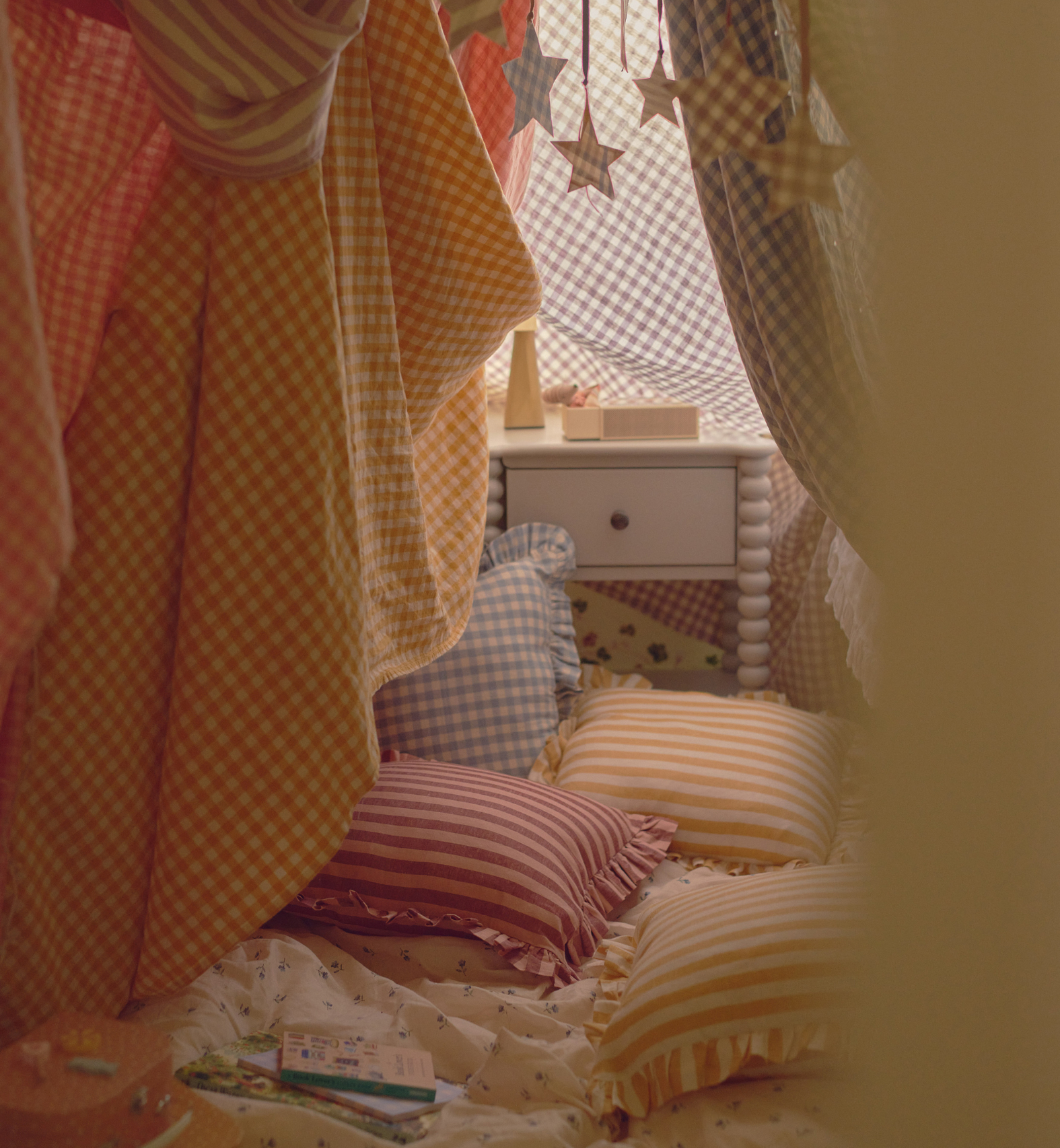 A child's den made with colourful bedsheets