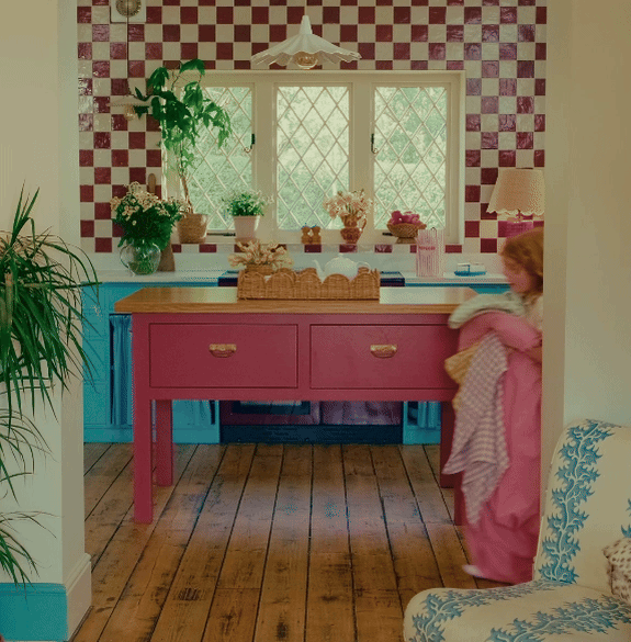 A little girl, Martha, running through a kitchen carrying bedsheets