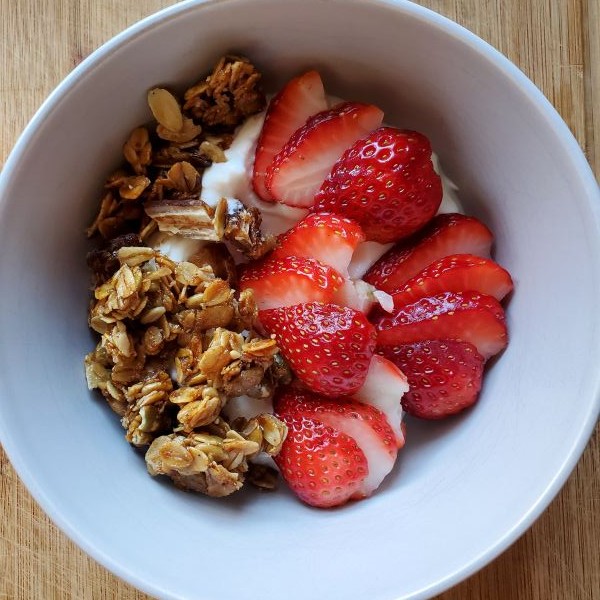 Homemade granola with strawberries on yogurt