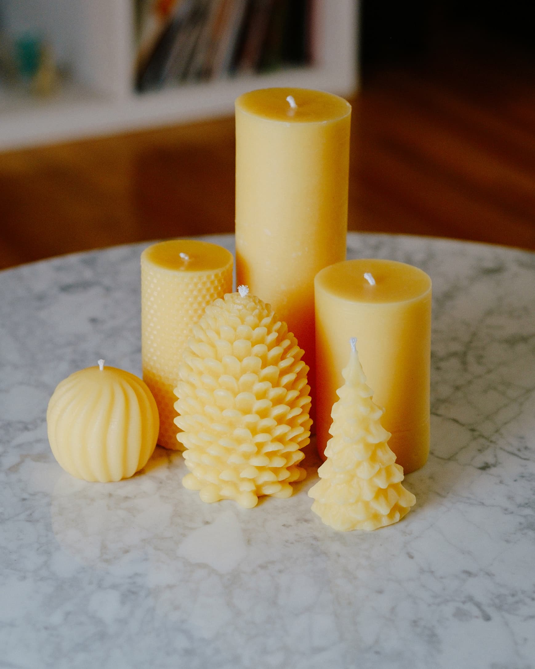 A group of beeswax candles on a marble table