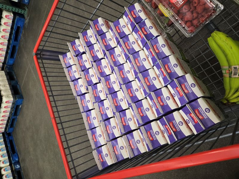 A cart full of cream, a couple of bananas, and a package of raspberries