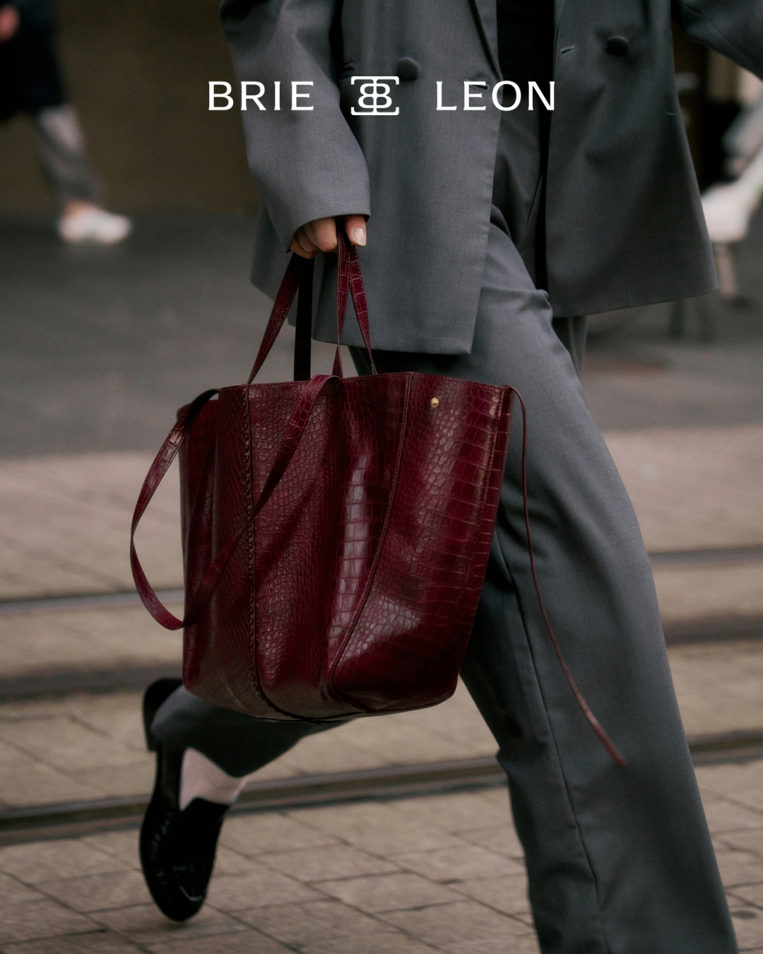 an image of a woman carrying a red bag on a sidewalk