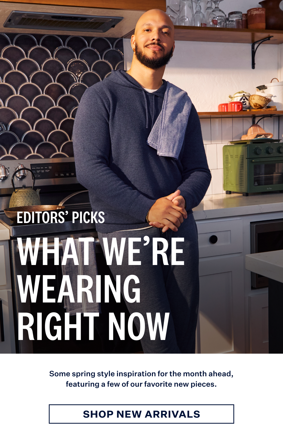 Man wearing Tech Linen Hoodie in Navy Heather leaning against a kitchen counter. Text: "Editors' Picks: What We're Wearing Right Now." with Shop New Arrivals button at the bottom 